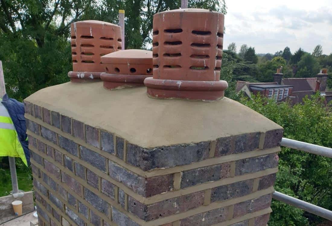 Harrington roofer in hi-vis finishing a rebuilt chimney stack